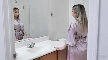 Touching her bald pussy turns her on, so she uses a vibrator to pleasure herself on the bathroom counter